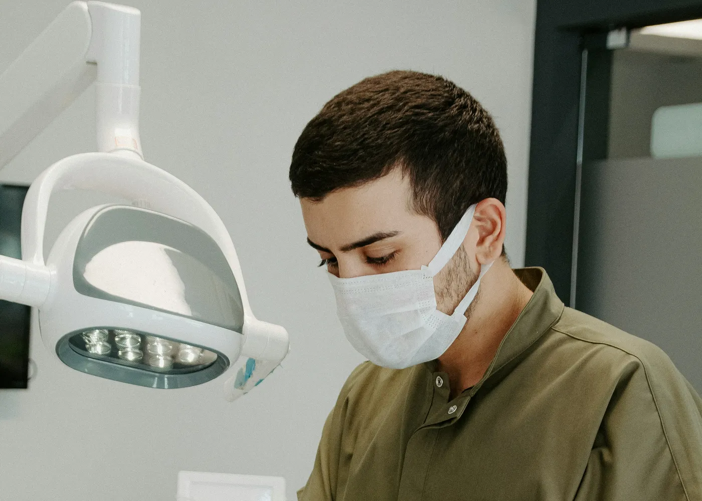 Odontólogo trabajando con mascarilla y lámpara